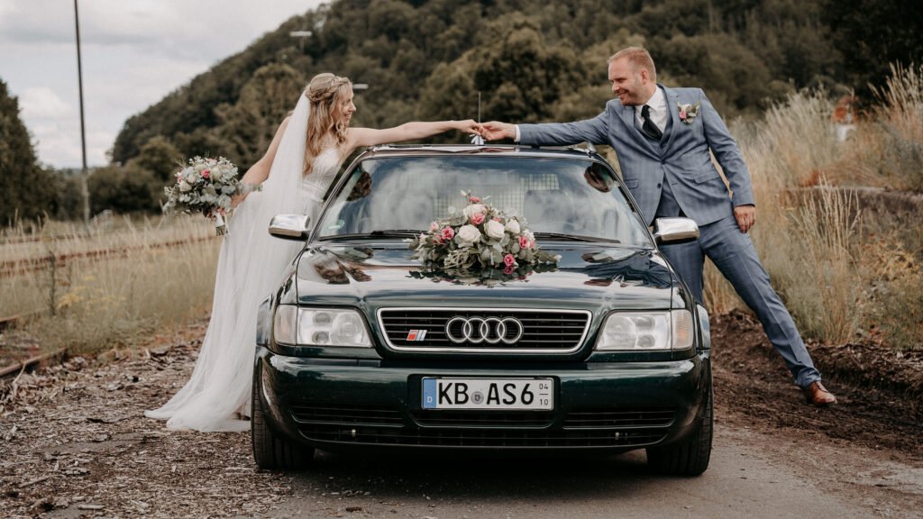 Mark und Steffi vor ihrem Hochzeitsauto beim Paarshooting.