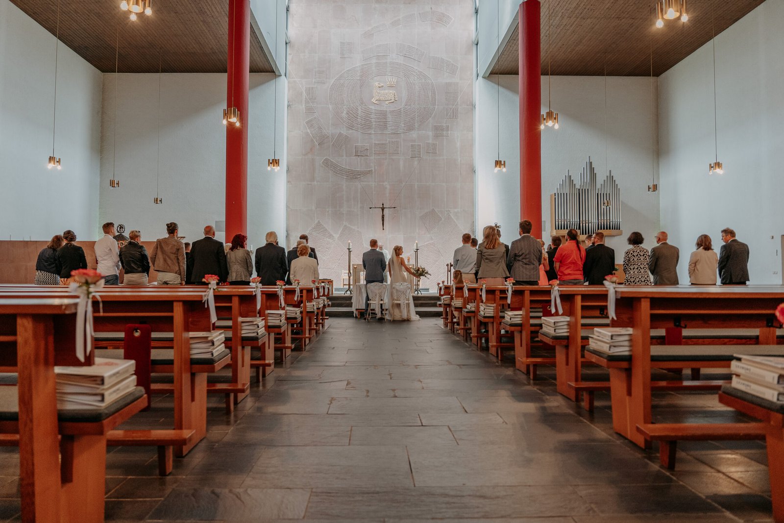 Das Brautpaar und die Hochzeitsgesellschaft vor dem Altar.